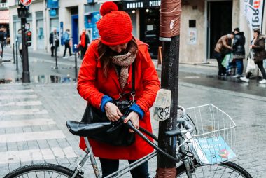 woman on red coat and red knit hat on pedestrian crossing